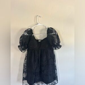 allison and kelly black dress with pattern and puffy sleeves.